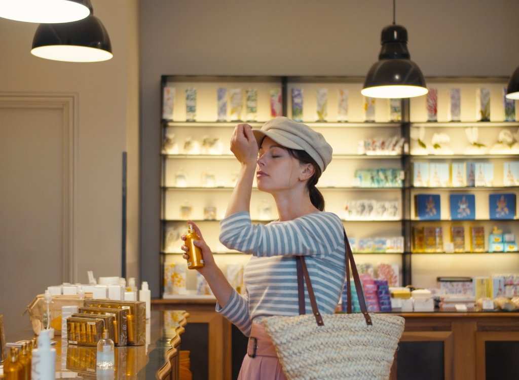 Lady smelling perfume in store